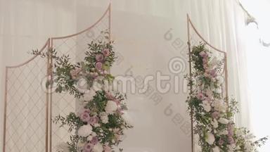 餐厅婚礼装饰。 金色的婚礼祭坛，装饰着绿色植物和白色玫瑰的花环
